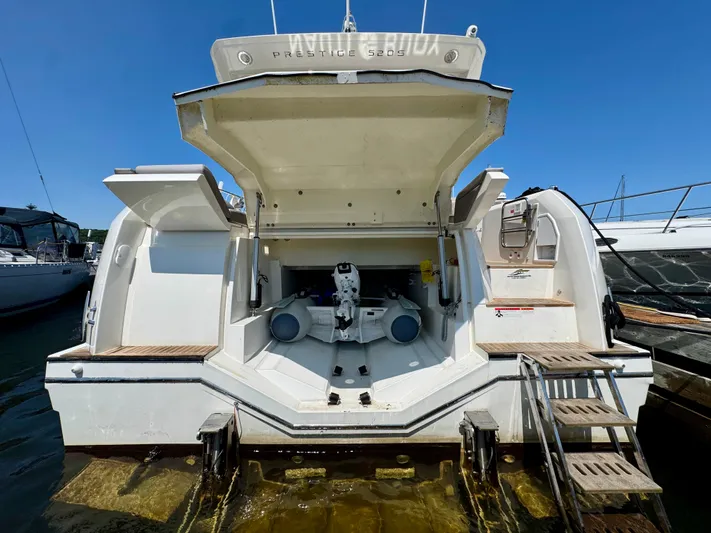  Yacht Photos Pics 2023 Prestige 520S yacht stern view with open storage compartment and ladder.