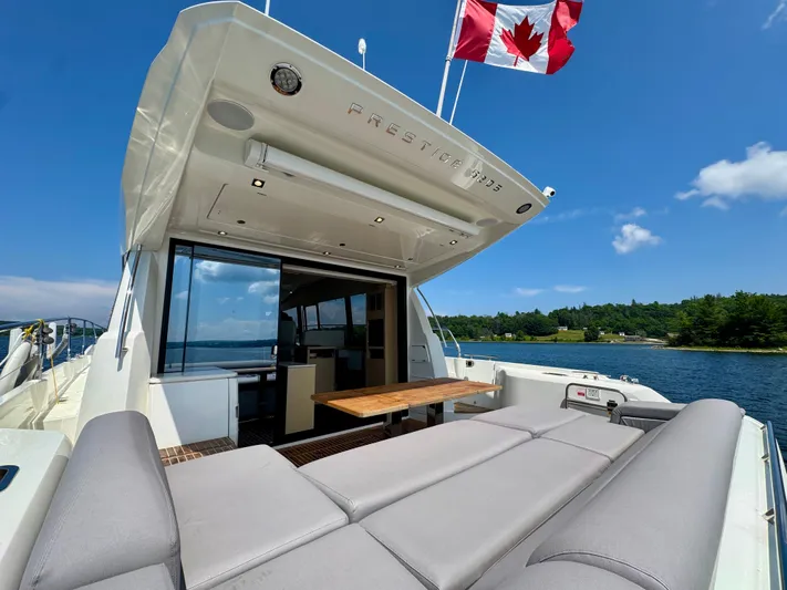  Yacht Photos Pics 2023 Prestige 520S yacht with Canadian flag, featuring spacious deck and luxurious seating.
