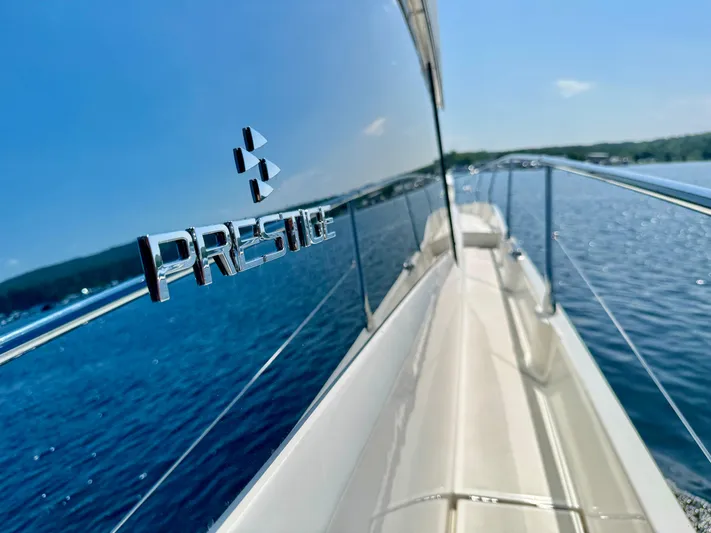  Yacht Photos Pics 2023 Prestige 520S yacht on serene blue water, showcasing sleek design and luxury.