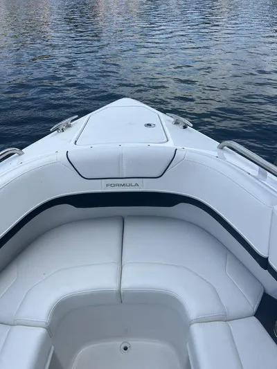  Yacht Photos Pics 2025 Formula 290 Bowrider boat interior with white seating on calm water.