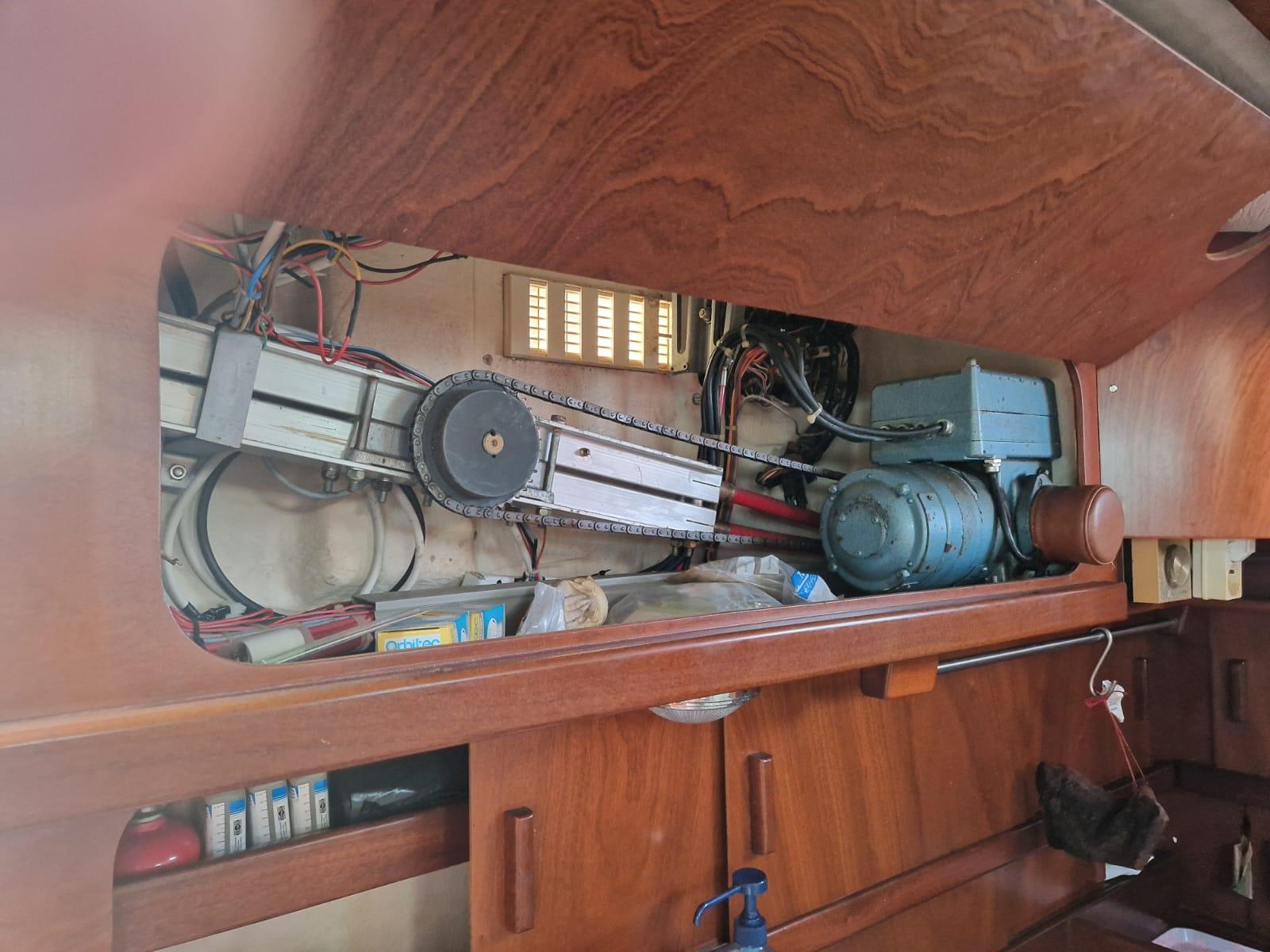 Interior view of 1982 Amel Maramu sailboat showing mechanical components and wooden cabinetry.