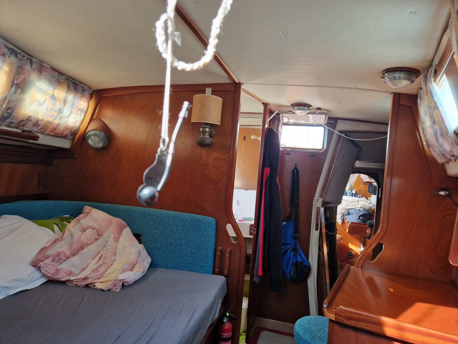 Interior of 1982 Amel Maramu sailboat with cozy cabin and wooden furnishings.