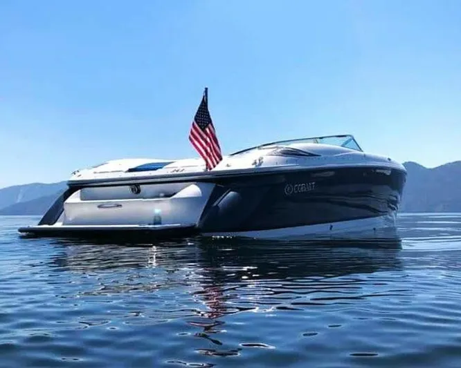  Yacht Photos Pics 2005 Cobalt 343 boat on calm water with American flag, scenic mountain backdrop.