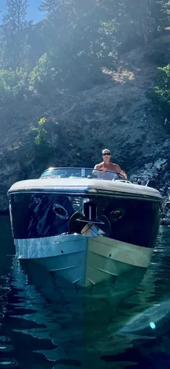  Yacht Photos Pics 2005 Cobalt 343 boat on water, with a person steering, surrounded by rocky landscape.
