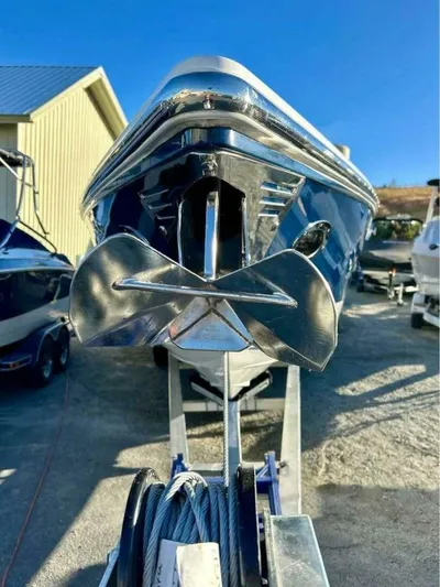  Yacht Photos Pics 2005 Cobalt 343 boat with a shiny anchor, parked on a trailer under clear blue sky.