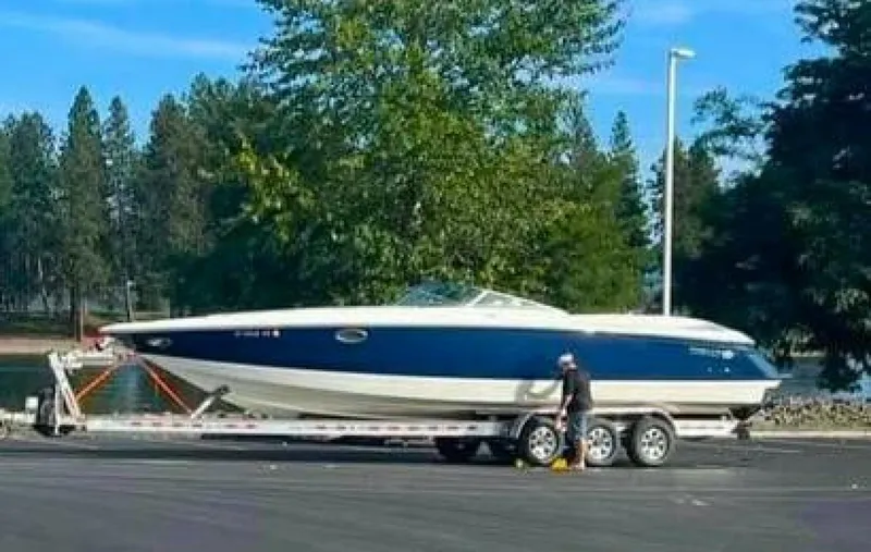  Yacht Photos Pics 2005 Cobalt 343 boat on trailer, parked near a lake with trees in the background.