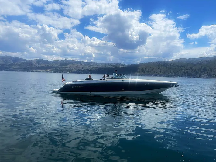  Yacht Photos Pics 2005 Cobalt 343 boat cruising on a scenic lake under a partly cloudy sky.