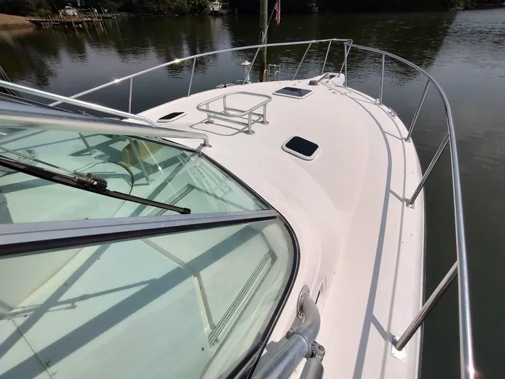 Reel Time Yacht Photos Pics 2005 Rampage 38 Express boat deck with railing, docked on calm water.