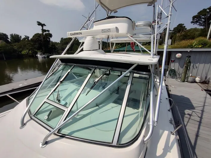 Reel Time Yacht Photos Pics 2005 Rampage 38 Express boat with Garmin radar, docked near lush greenery.