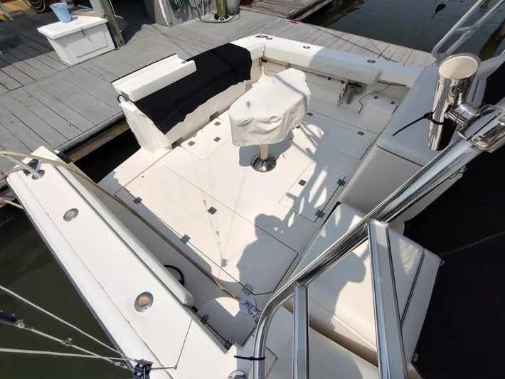 Reel Time Yacht Photos Pics 2005 Rampage 38 Express boat deck with seating and covered table at dock.