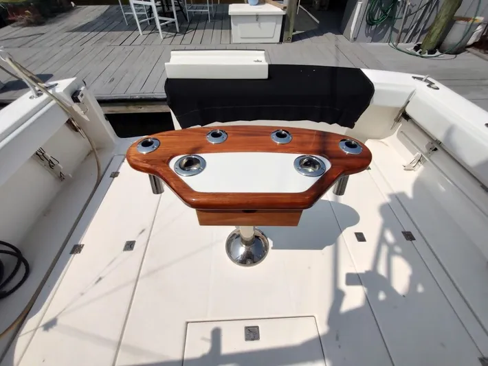 Reel Time Yacht Photos Pics 2005 Rampage 38 Express boat deck with wooden table and rod holders.
