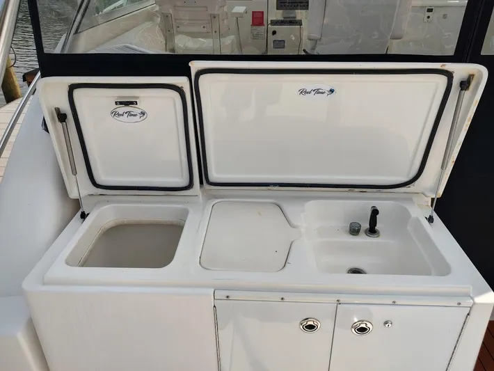 Reel Time Yacht Photos Pics 2005 Rampage 38 Express boat sink and storage area with open compartments.