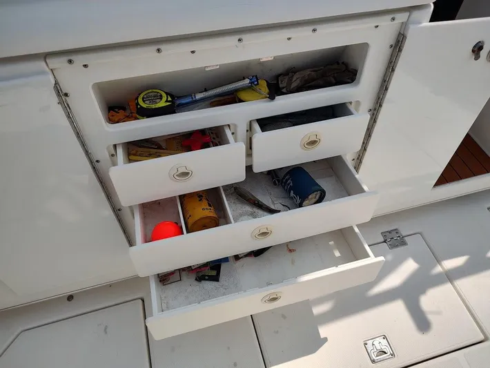 Reel Time Yacht Photos Pics Storage drawers on a 2005 Rampage 38 Express boat, containing various tools and items.