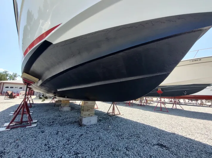 Reel Time Yacht Photos Pics 2005 Rampage 38 Express boat hull on stands in a gravel yard.