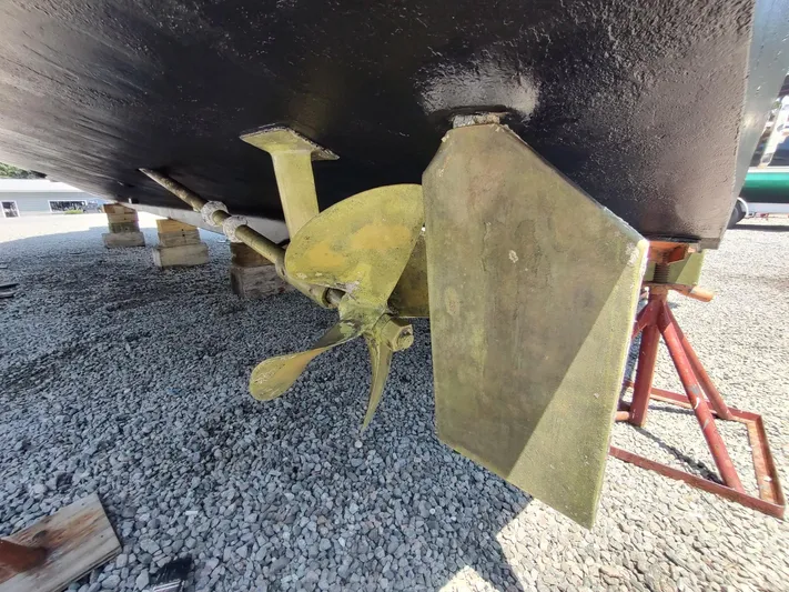 Reel Time Yacht Photos Pics 2005 Rampage 38 Express boat propeller and rudder on gravel.