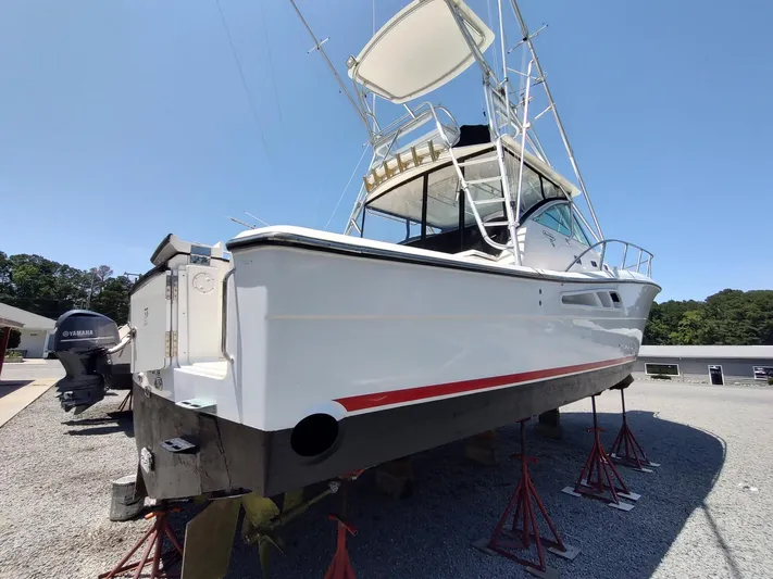 Reel Time Yacht Photos Pics 2005 Rampage 38 Express boat on stands, side view, clear sky background.