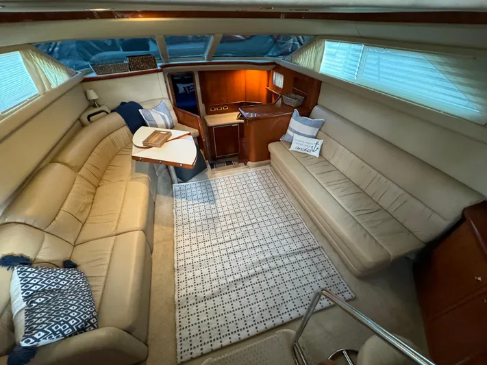 Fathom This Yacht Photos Pics Interior of 2001 Sea Ray 420 Aft Cabin with beige seating and wooden cabinetry.