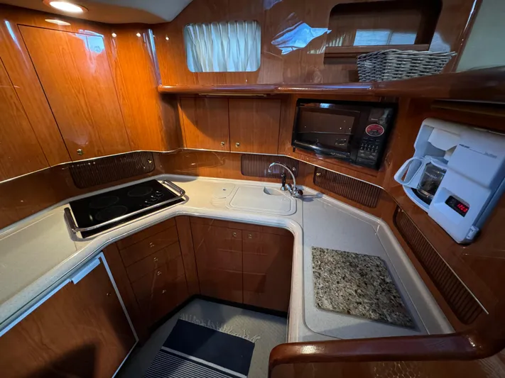 Fathom This Yacht Photos Pics 2001 Sea Ray 420 Aft Cabin kitchen with wood cabinetry and modern appliances.