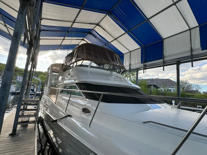Fathom This Yacht Photos Pics 2001 Sea Ray 420 Aft Cabin yacht docked under a blue canopy.