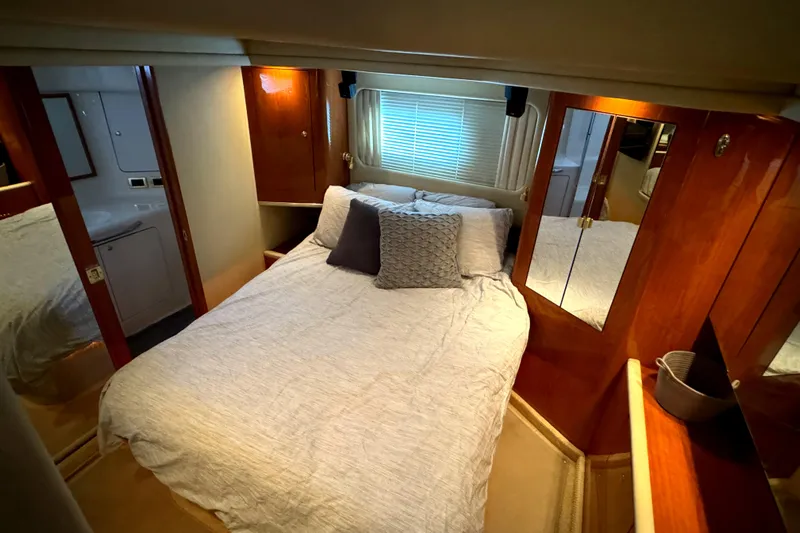 Fathom This Yacht Photos Pics Luxurious bedroom in 2001 Sea Ray 420 Aft Cabin yacht with cozy bedding and wooden accents.