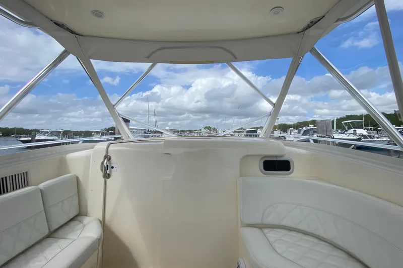  Yacht Photos Pics Interior view of a 2006 Intrepid 377 boat with white seating and marina backdrop.