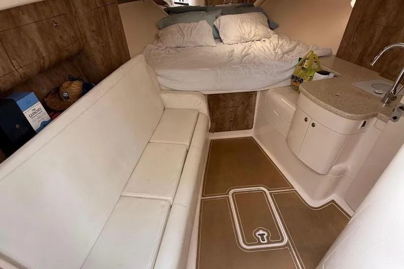  Yacht Photos Pics Interior of a 2006 Intrepid 377 boat with bed, sofa, and kitchenette.