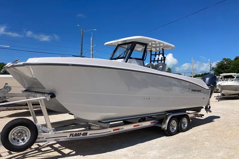 The Grey Ghost Yacht Photos Pics 2026 Twin Vee 280 GFX CC boat on trailer under clear blue sky.
