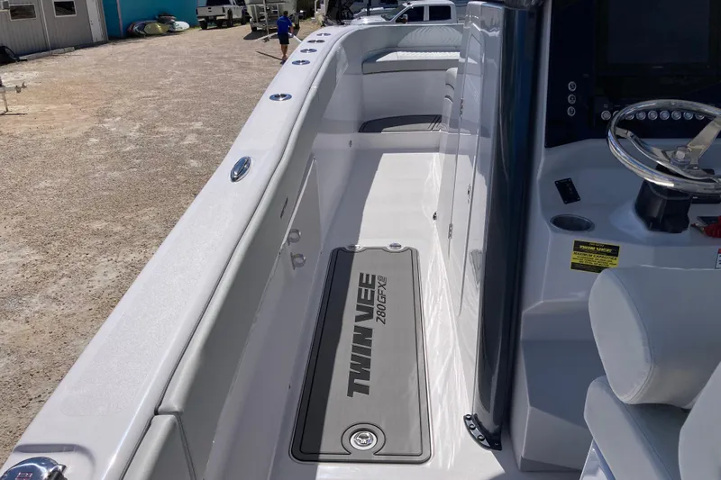 The Grey Ghost Yacht Photos Pics 2026 Twin Vee 280 GFX CC boat interior with steering wheel and seating area.