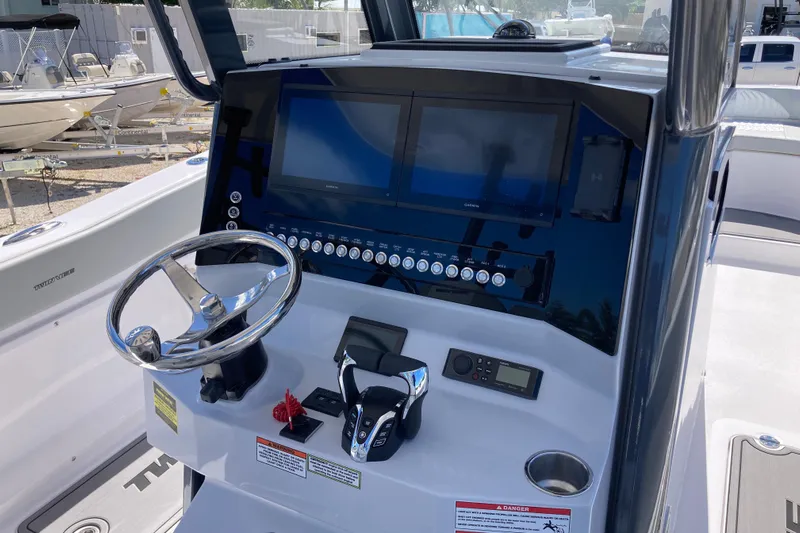 The Grey Ghost Yacht Photos Pics 2026 Twin Vee 280 GFX CC boat dashboard with steering wheel and electronic controls.