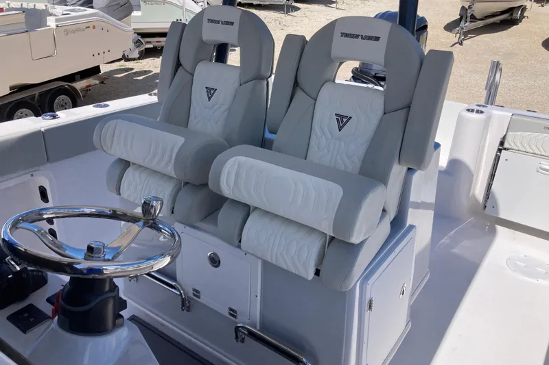 The Grey Ghost Yacht Photos Pics 2026 Twin Vee 280 GFX CC boat interior with dual cushioned seats and steering wheel.