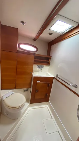  Yacht Photos Pics 2004 Hanse 531 yacht bathroom with wooden cabinetry and modern fixtures.