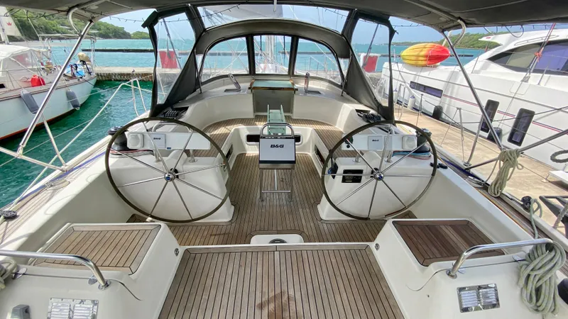  Yacht Photos Pics 2004 Hanse 531 yacht cockpit with dual steering wheels, docked at a marina.