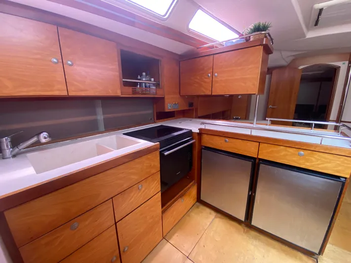  Yacht Photos Pics Luxurious 2004 Hanse 531 yacht kitchen with wooden cabinets and modern appliances.
