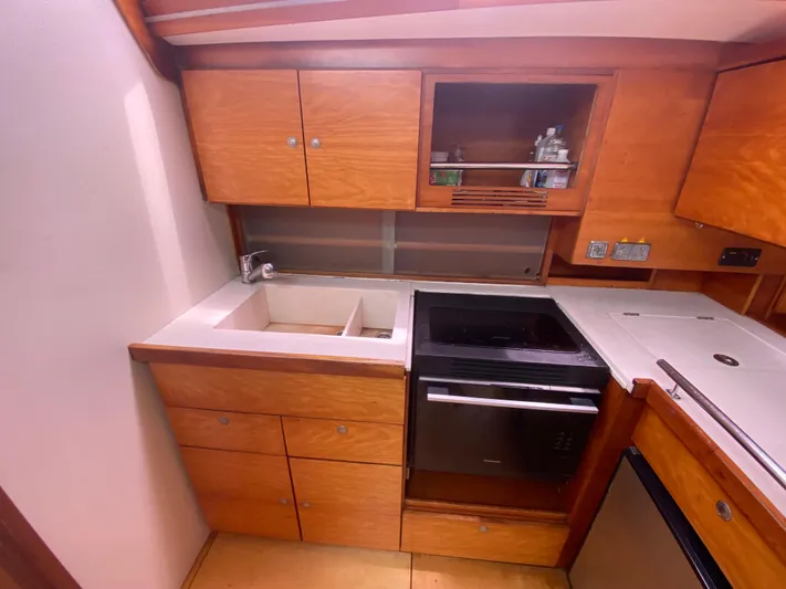  Yacht Photos Pics Wooden kitchen interior of 2004 Hanse 531 yacht with sink and stove.