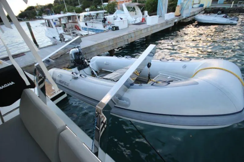 Ruckus Yacht Photos Pics Fountaine Pajot Catamaran Elba 45 (2021) with inflatable dinghy docked at marina.