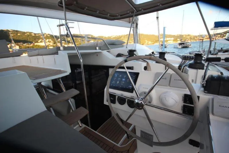 Ruckus Yacht Photos Pics 2021 Fountaine Pajot Catamaran Elba 45 cockpit with steering wheel and navigation equipment.
