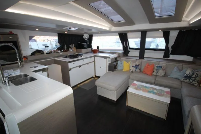 Ruckus Yacht Photos Pics Luxurious interior of 2021 Fountaine Pajot Catamaran Elba 45 with modern kitchen and cozy seating area.