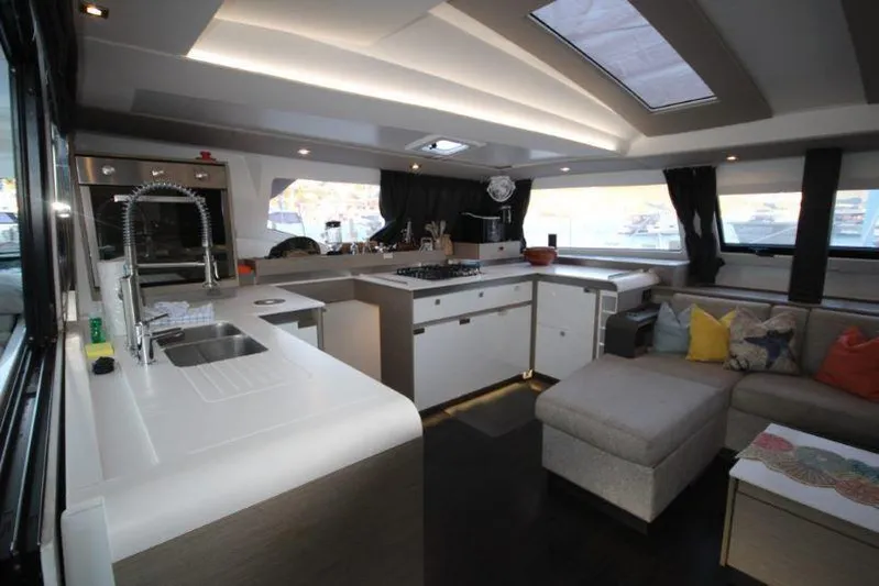 Ruckus Yacht Photos Pics Luxurious interior of 2021 Fountaine Pajot Catamaran Elba 45 with modern kitchen and seating area.