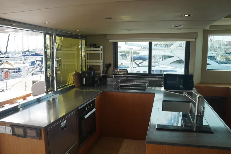 Melissa Yacht Photos Pics Modern kitchen interior on 2022 Silent 60 yacht, featuring sleek countertops and marina view.
