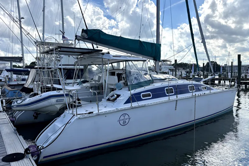 Serenity Yacht Photos Pics 2003 PDQ 36 Capella catamaran docked at marina under cloudy sky.