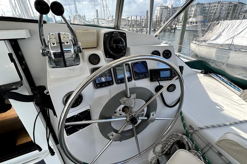 Serenity Yacht Photos Pics Steering wheel and controls of a 2003 PDQ 36 Capella yacht in a marina.