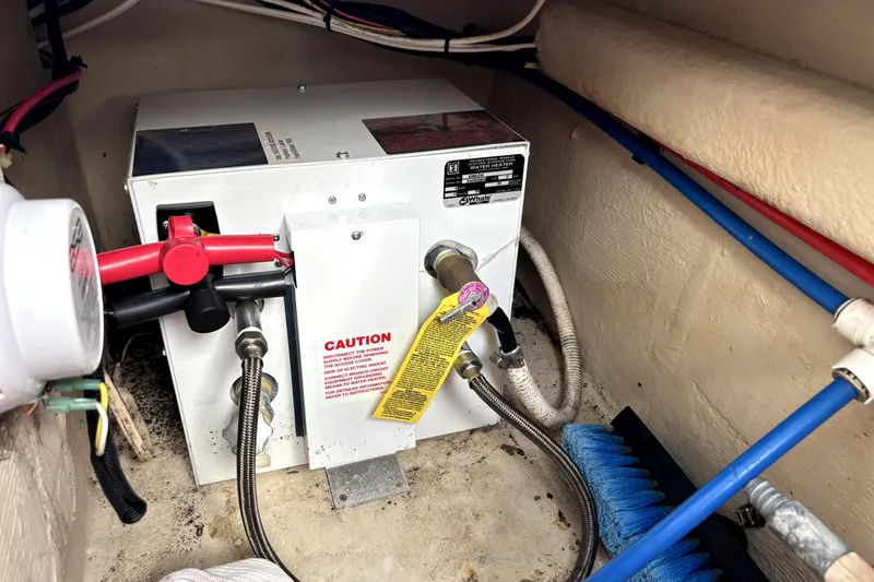 Serenity Yacht Photos Pics PDQ 36 Capella 2003 boat water heater with caution label and connected hoses.