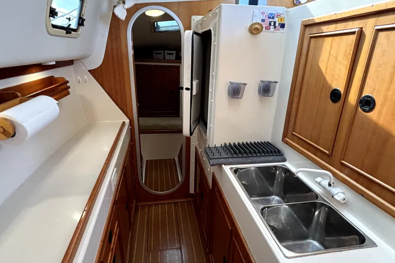 Serenity Yacht Photos Pics Interior of 2003 PDQ 36 Capella yacht kitchen with dual sinks and wooden cabinetry.