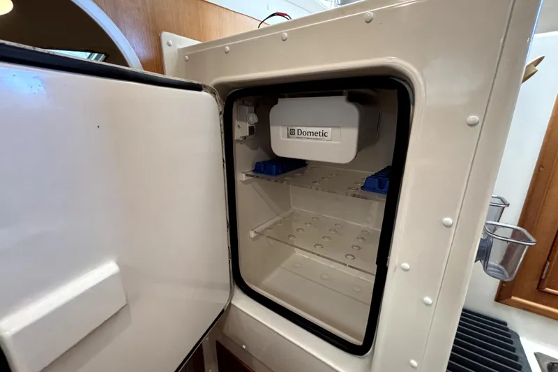 Serenity Yacht Photos Pics Open Dometic fridge inside 2003 PDQ 36 Capella boat, showcasing interior storage space.