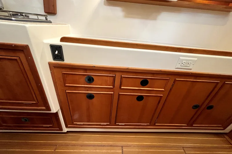 Serenity Yacht Photos Pics Wooden cabinetry in a 2003 PDQ 36 Capella boat interior, featuring drawers and electrical outlets.