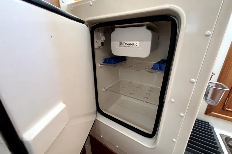 Serenity Yacht Photos Pics Open Dometic refrigerator inside 2003 PDQ 36 Capella boat, showing empty shelves.