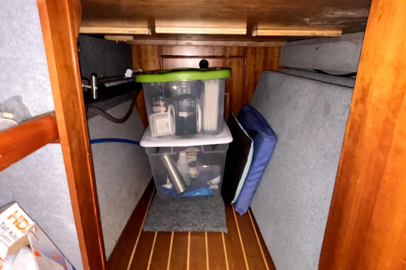 Serenity Yacht Photos Pics Storage area in 2003 PDQ 36 Capella boat with plastic containers and cushions.