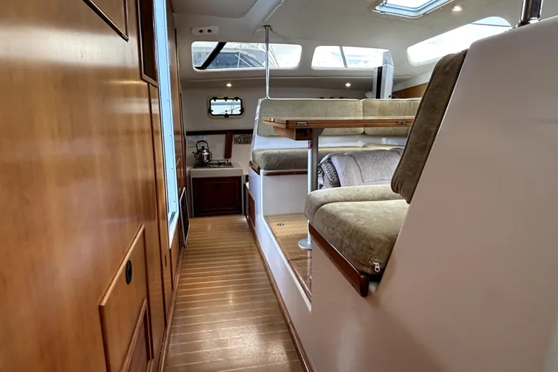 Serenity Yacht Photos Pics Interior of 2003 PDQ 36 Capella catamaran with cozy seating and wooden finishes.