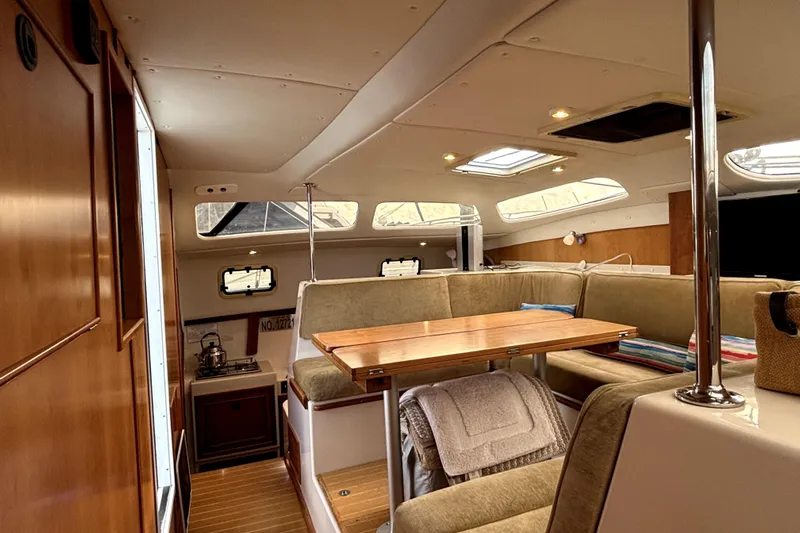 Serenity Yacht Photos Pics Interior of 2003 PDQ 36 Capella catamaran with cozy seating and wooden accents.