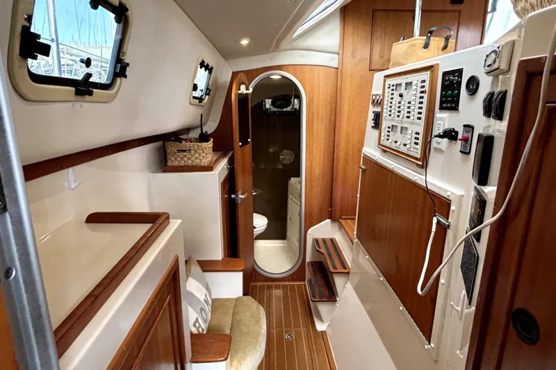 Serenity Yacht Photos Pics Interior of 2003 PDQ 36 Capella sailboat, featuring wood paneling and control panel.